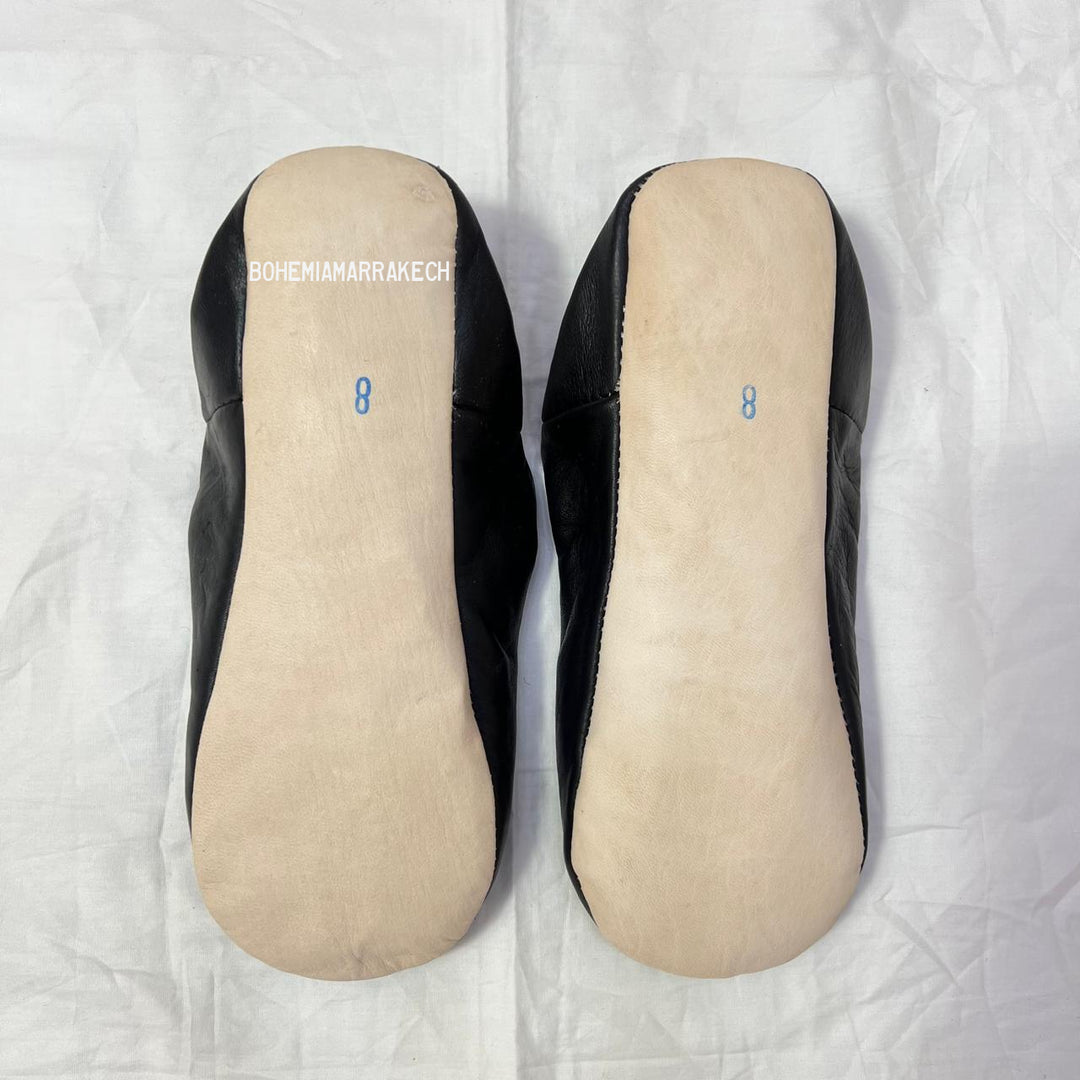 Handmade Moroccan leather babouche slippers with traditional pointed shape and hand-stitched edges.