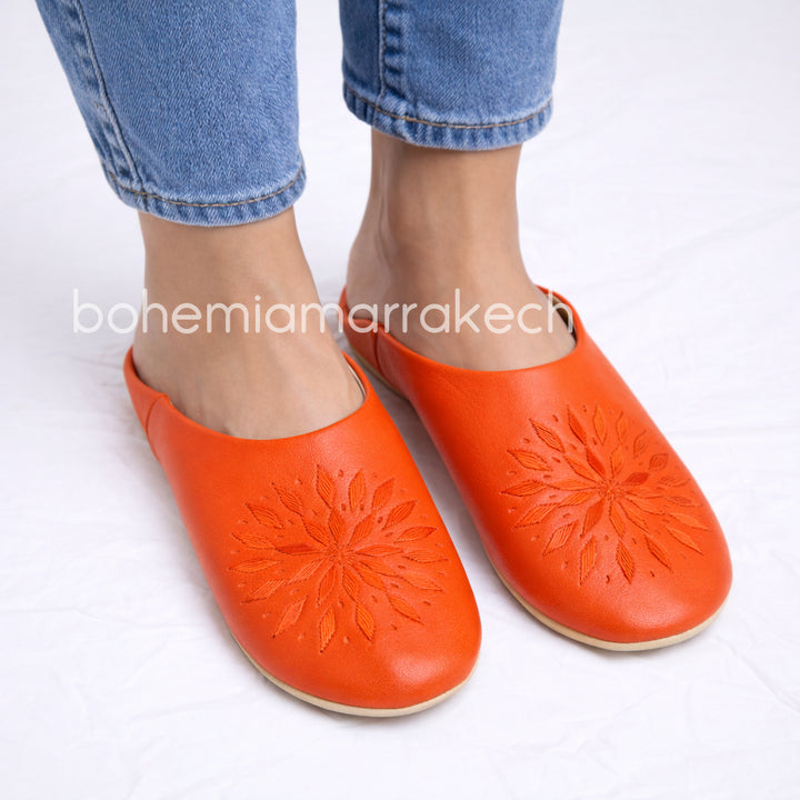 Handmade Moroccan babouche slippers in orange leather with traditional hand-stitched design, fully hand-stitched by artisans.