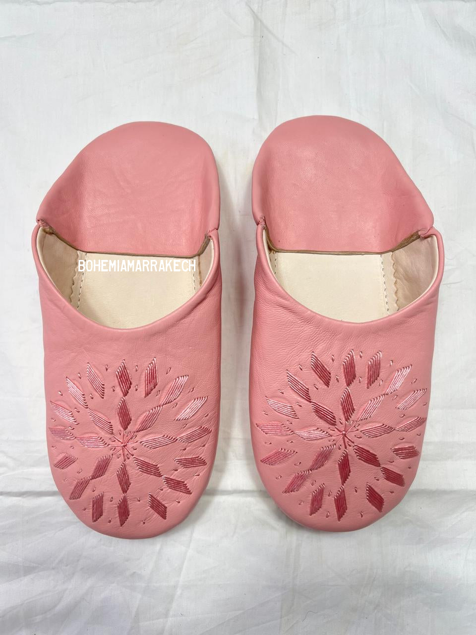 Fully hand-stitched Moroccan babouche slippers in soft pink leather with stitched floral design, handmade in Morocco.