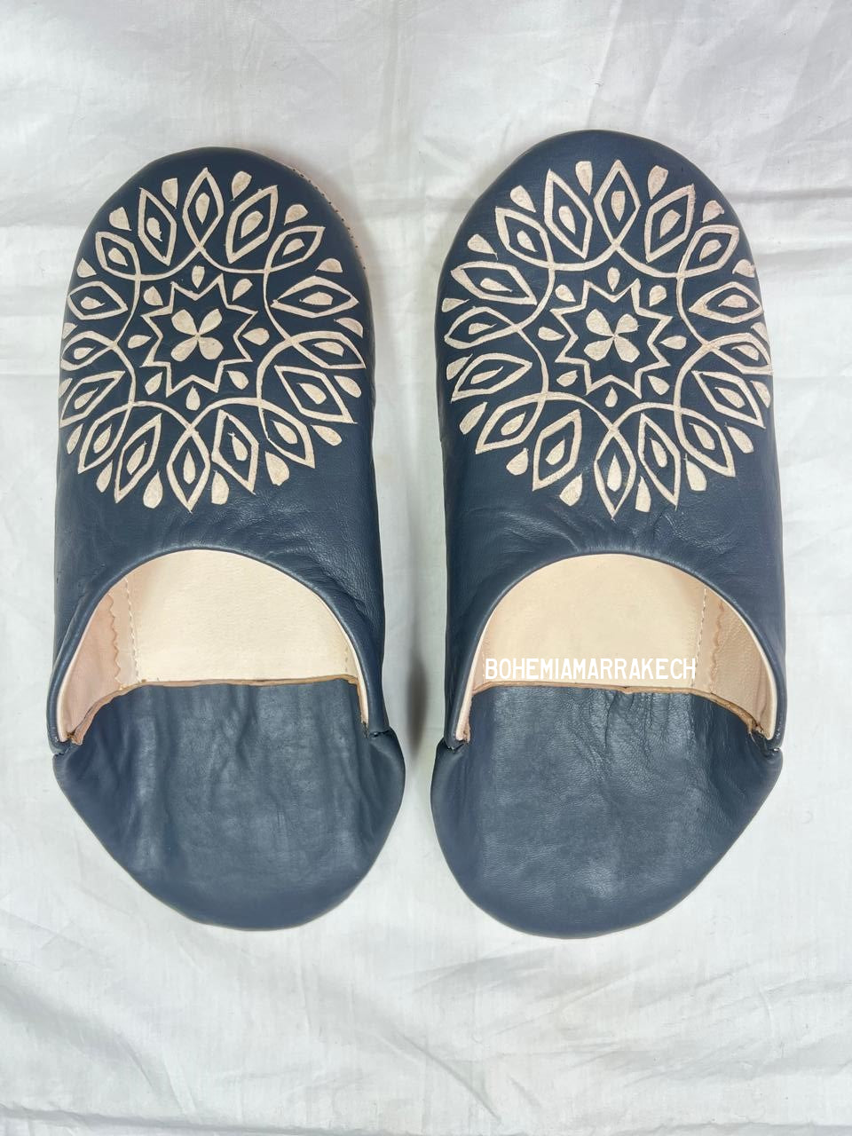 Handmade Moroccan babouche slippers in dark gray leather with hand-carved decorative design, crafted by artisans in Morocco.