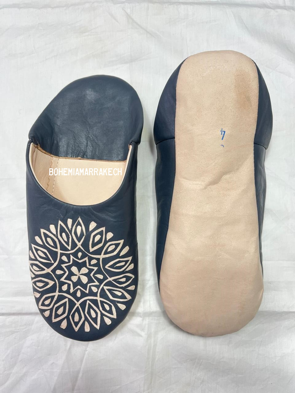 Handmade Moroccan babouche slippers in dark gray leather with hand-carved decorative design, crafted by artisans in Morocco.