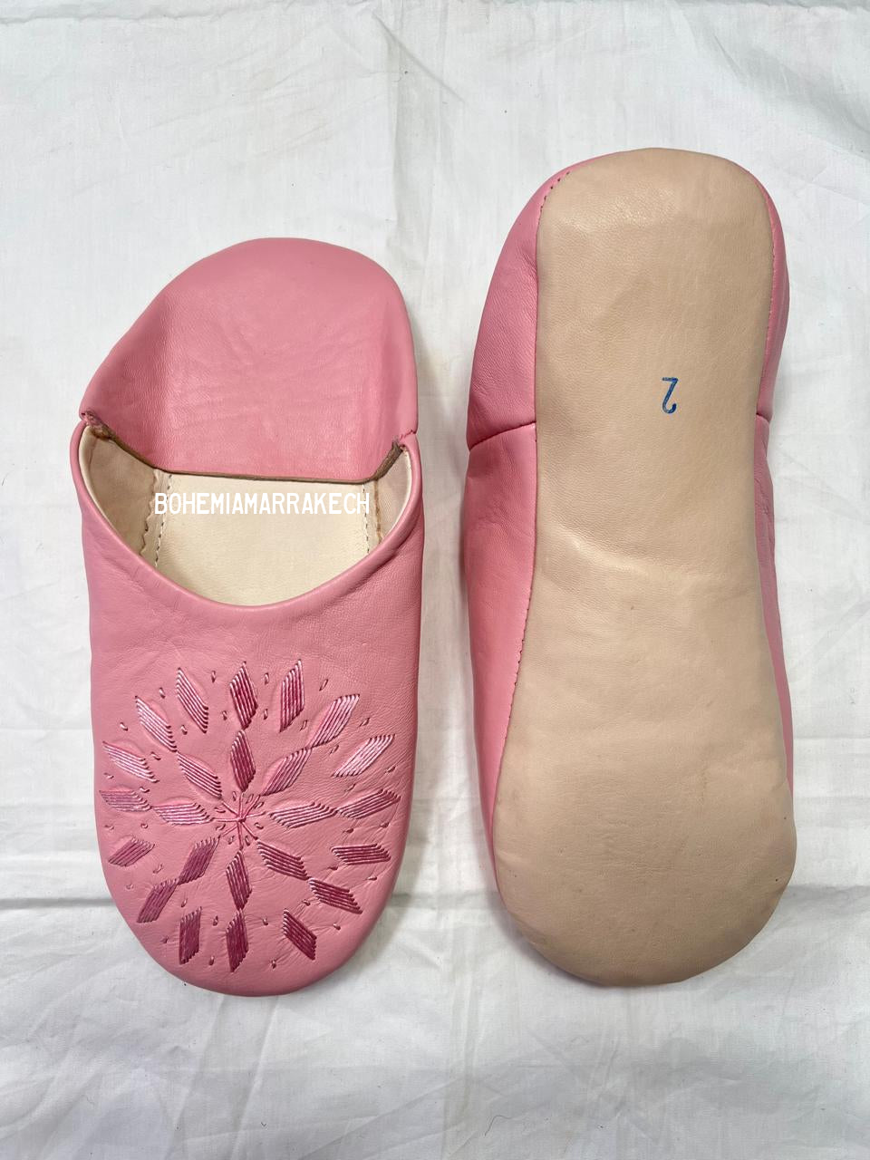 Fully hand-stitched Moroccan babouche slippers in soft pink leather with stitched floral design, handmade in Morocco.