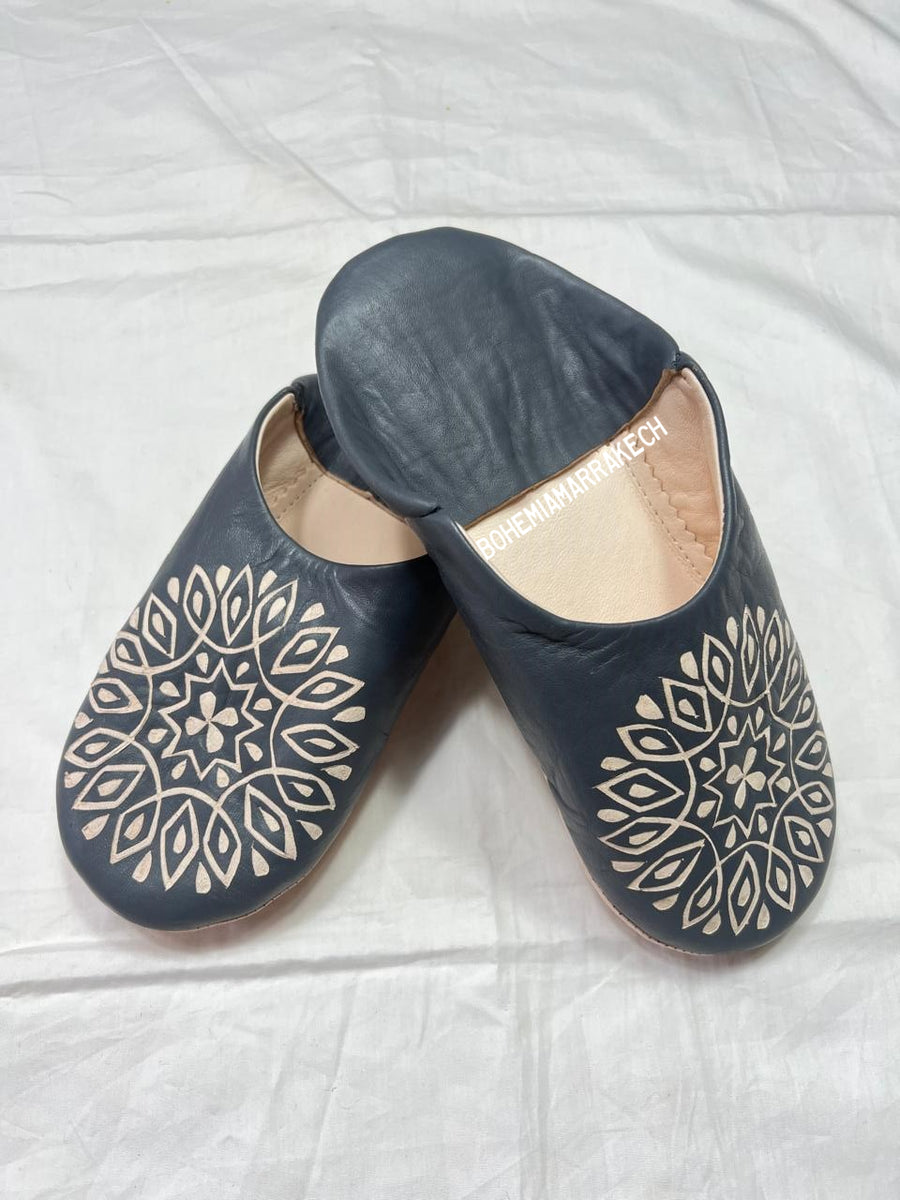 Handmade Moroccan babouche slippers in dark gray leather with hand-carved decorative design, crafted by artisans in Morocco.