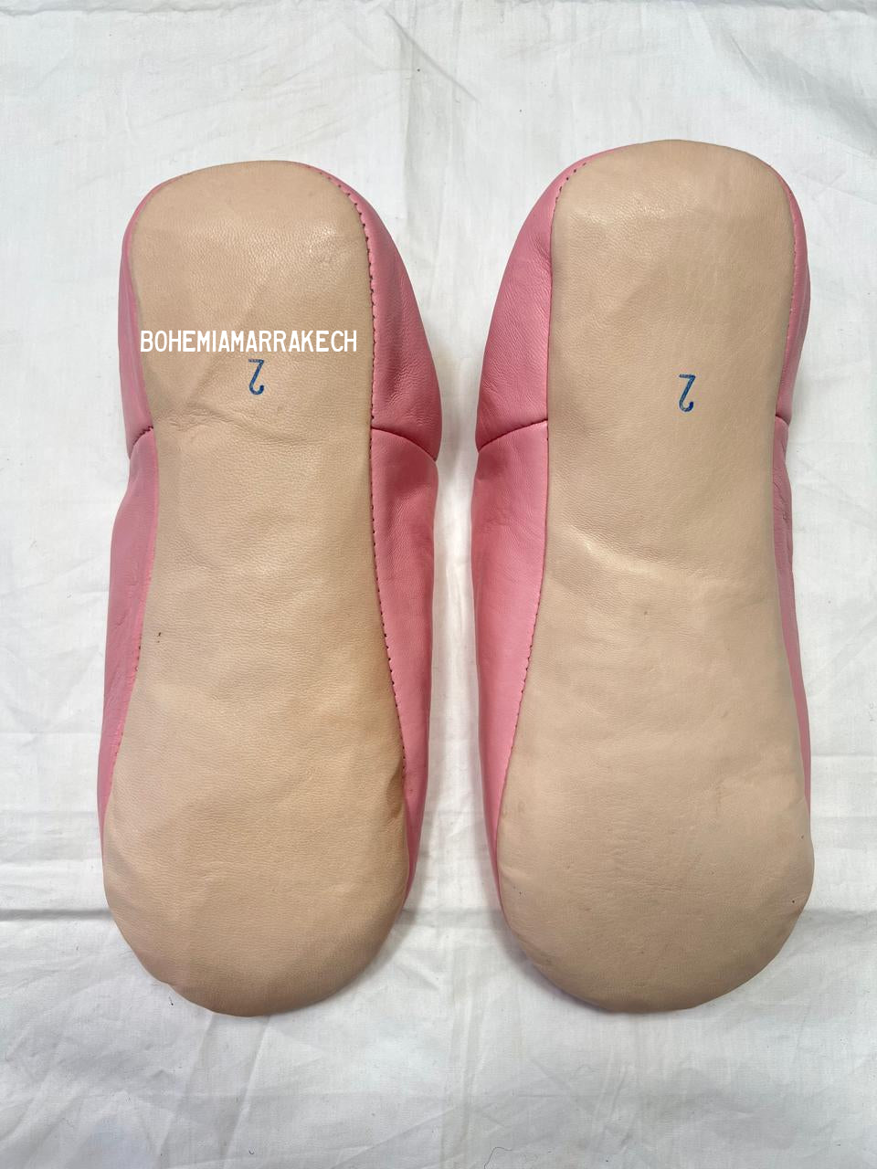 Fully hand-stitched Moroccan babouche slippers in soft pink leather with stitched floral design, handmade in Morocco.
