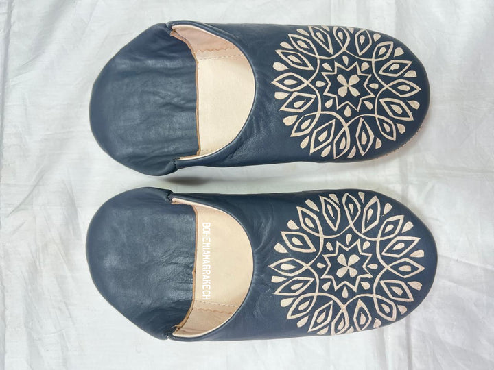 Handmade Moroccan babouche slippers in dark gray leather with hand-carved decorative design, crafted by artisans in Morocco.