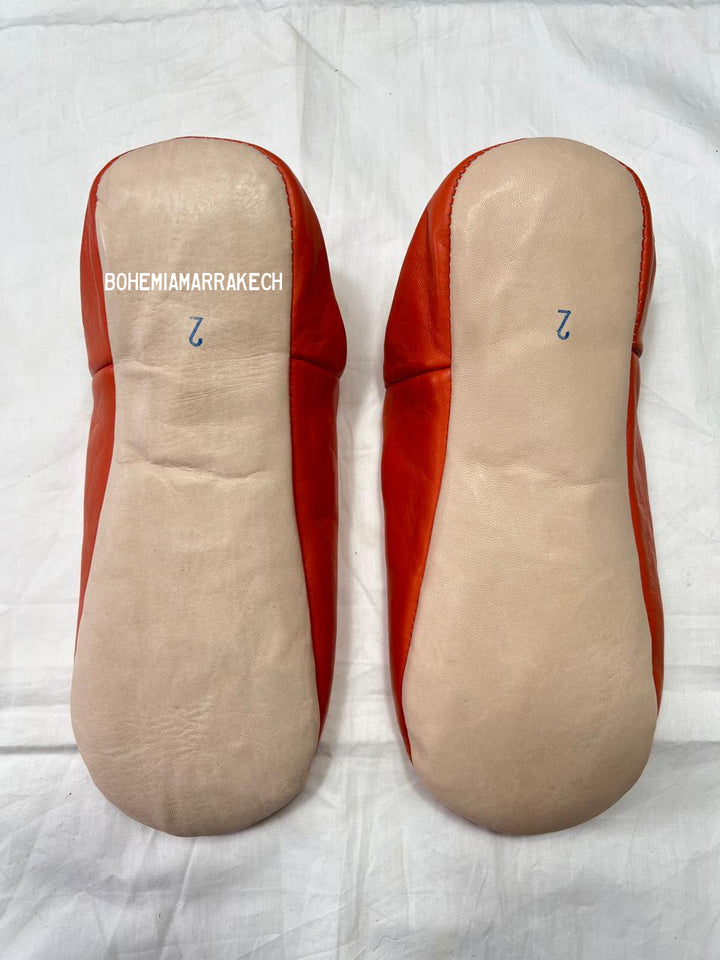 Handmade Moroccan babouche slippers in orange leather with traditional hand-stitched design, fully hand-stitched by artisans.