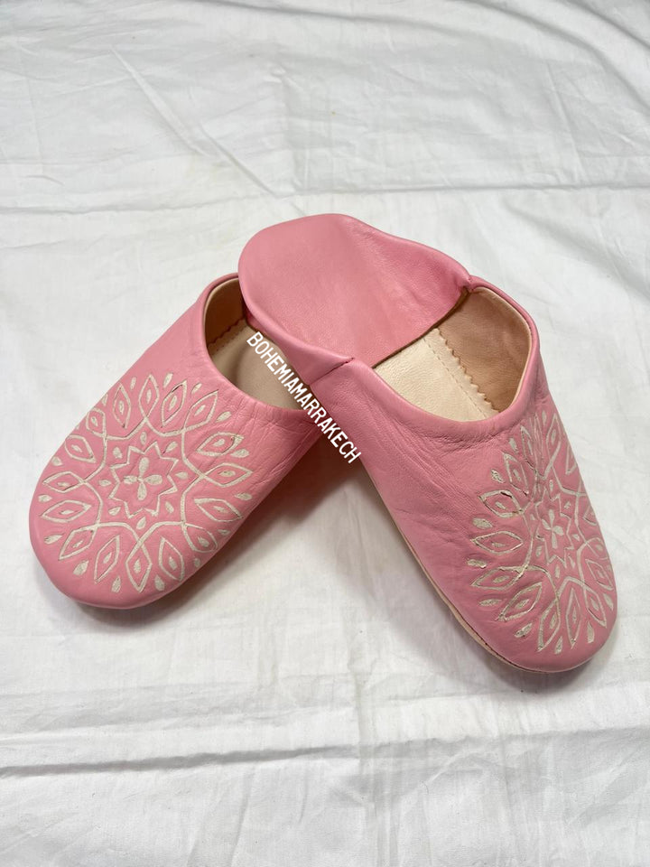 Handmade pink Moroccan babouche slippers with hand-carved geometric leather design on a white background