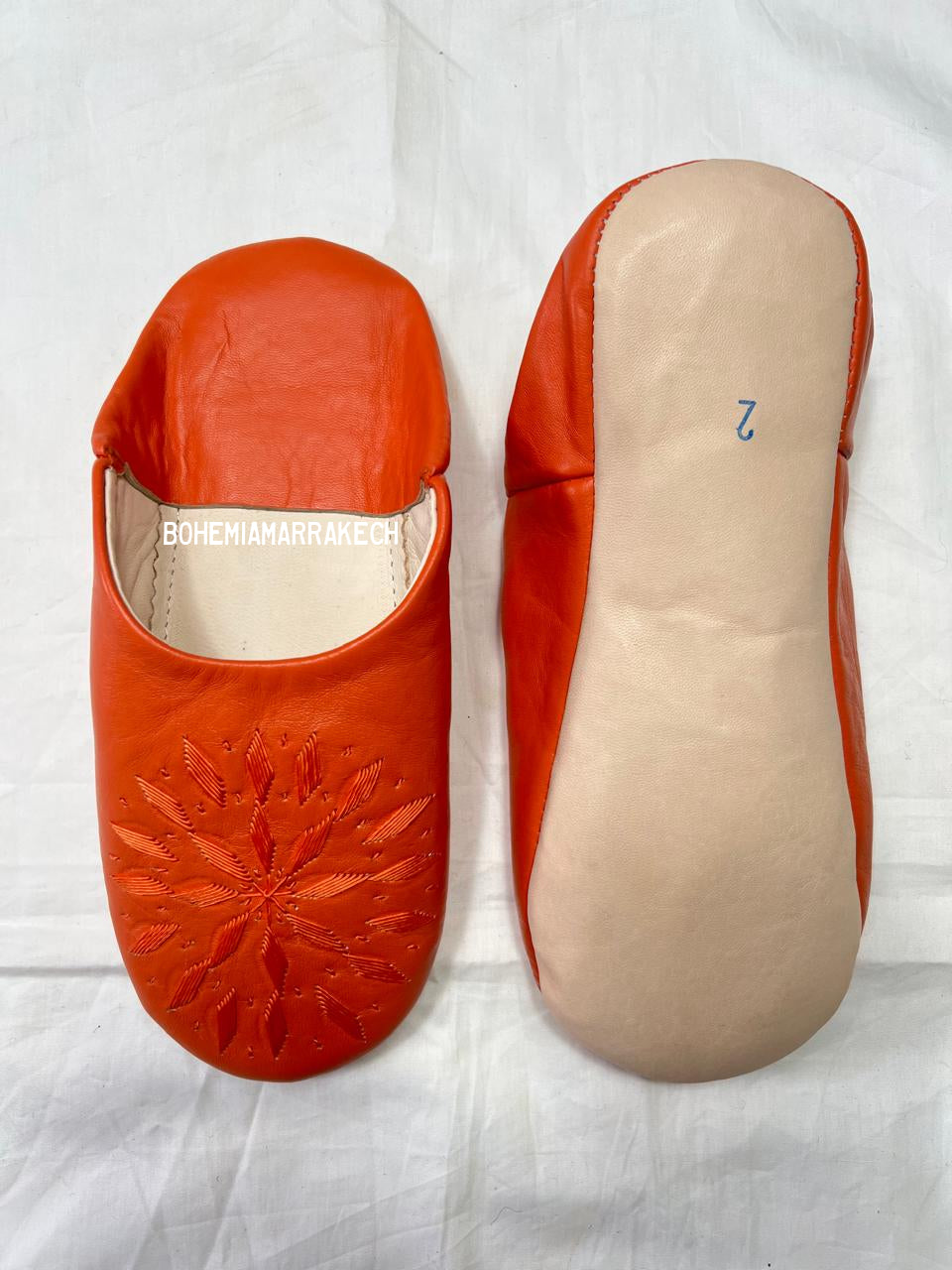 Handmade Moroccan babouche slippers in orange leather with traditional hand-stitched design, fully hand-stitched by artisans.