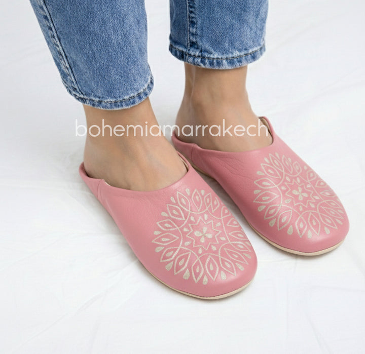Handmade pink Moroccan babouche slippers with hand-carved geometric leather design on a white background