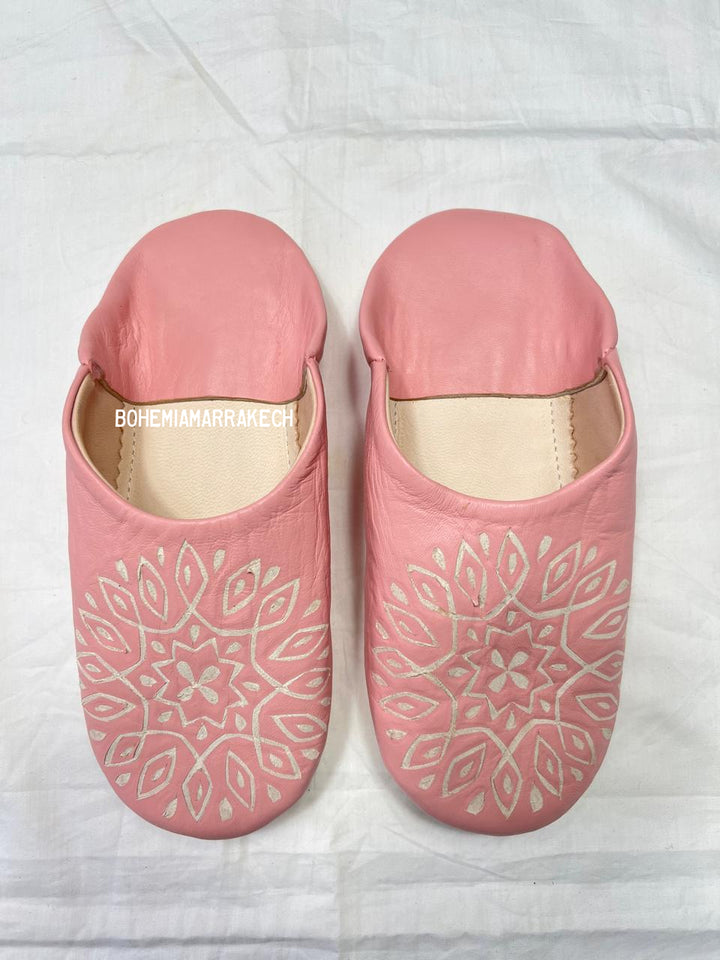Handmade pink Moroccan babouche slippers with hand-carved geometric leather design on a white background