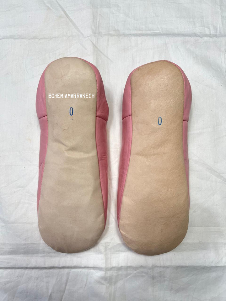 Handmade pink Moroccan babouche slippers with hand-carved geometric leather design on a white background