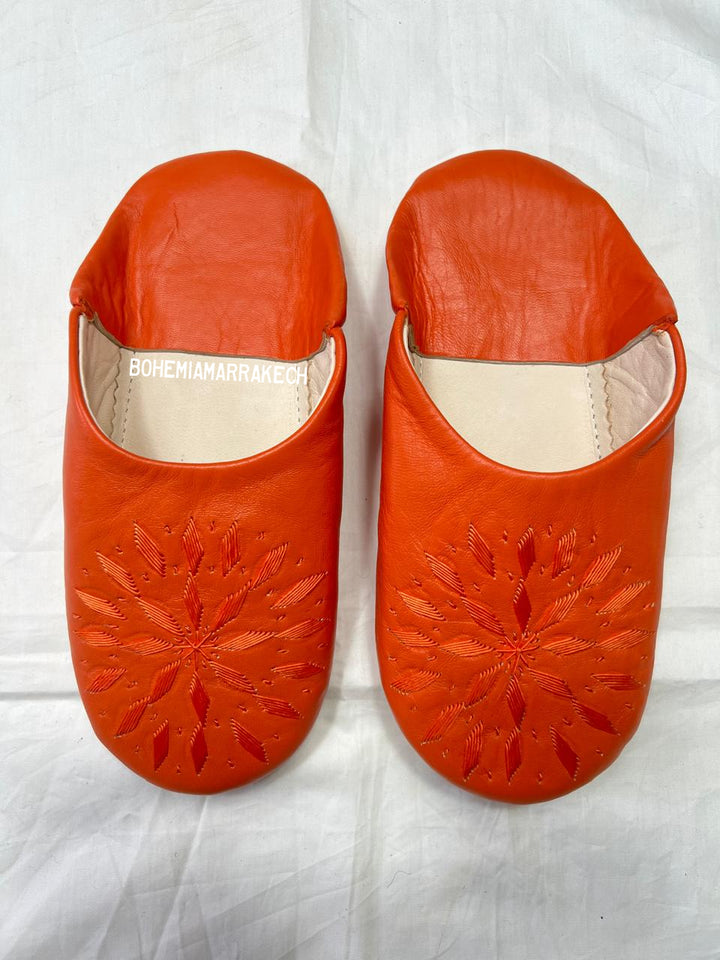 Handmade Moroccan babouche slippers in orange leather with traditional hand-stitched design, fully hand-stitched by artisans.