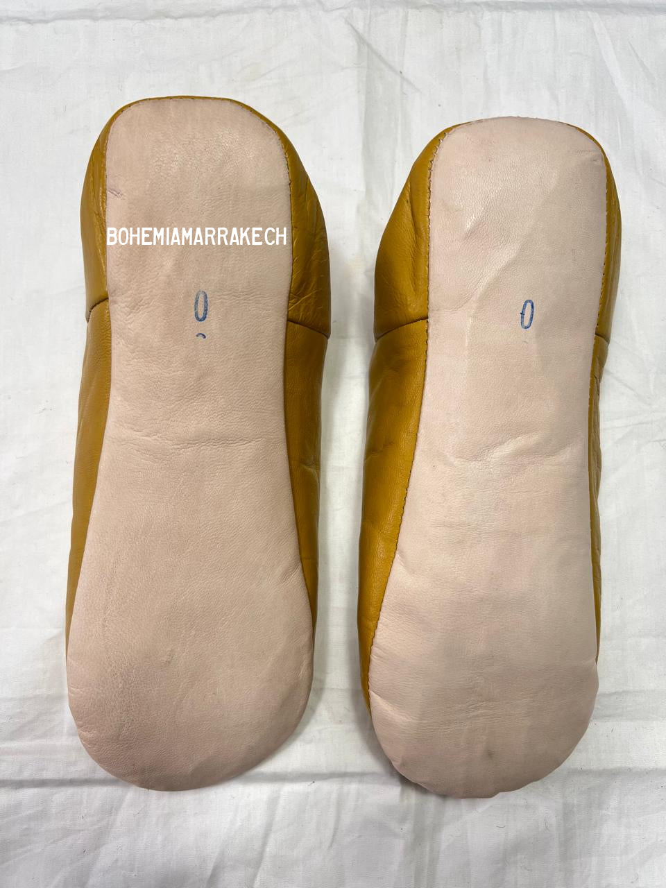 Mustard yellow Moroccan babouche slippers with carved geometric leather design on white background