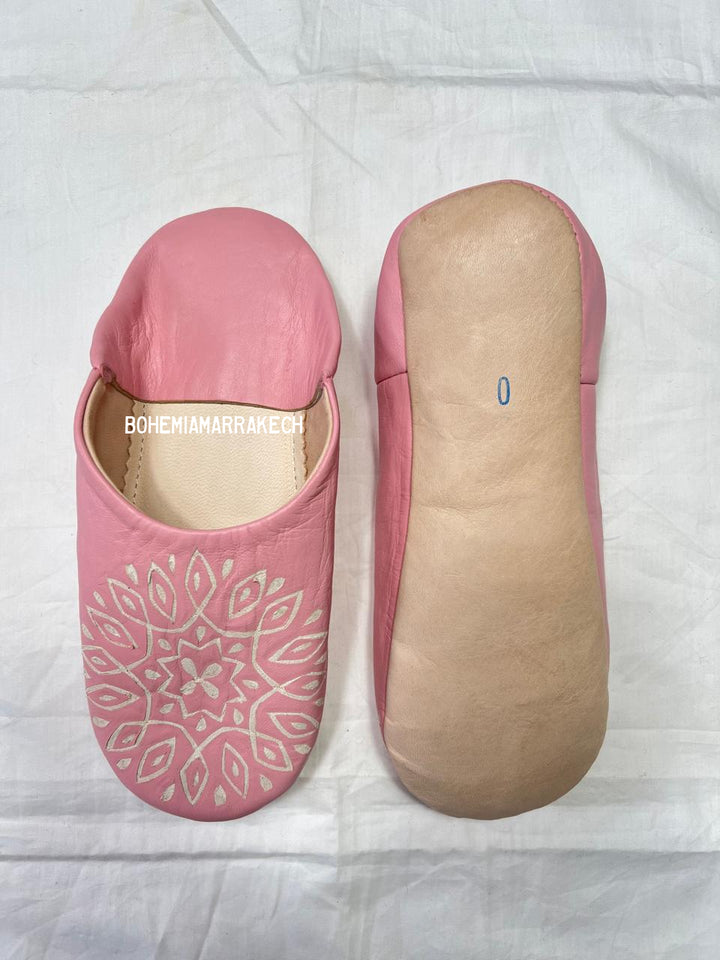 Handmade pink Moroccan babouche slippers with hand-carved geometric leather design on a white background
