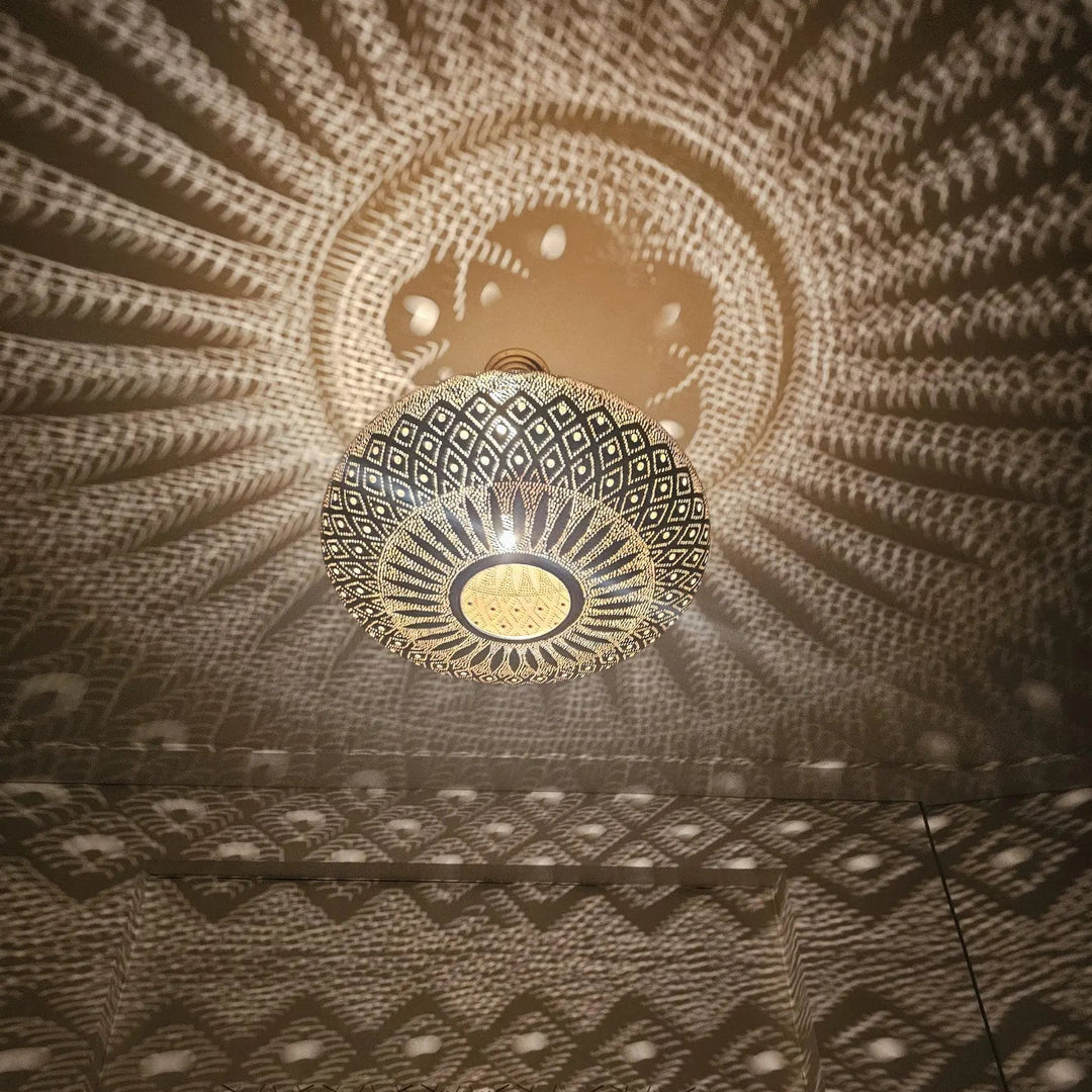 Decorative ceiling light fixture casting a pattern on the ceiling