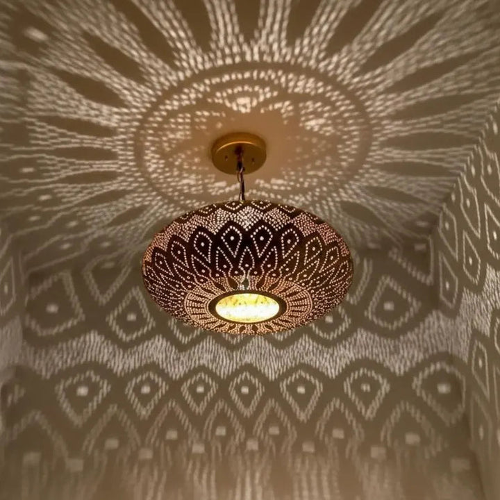 Decorative ceiling light fixture casting geometric shadows on a patterned wall.