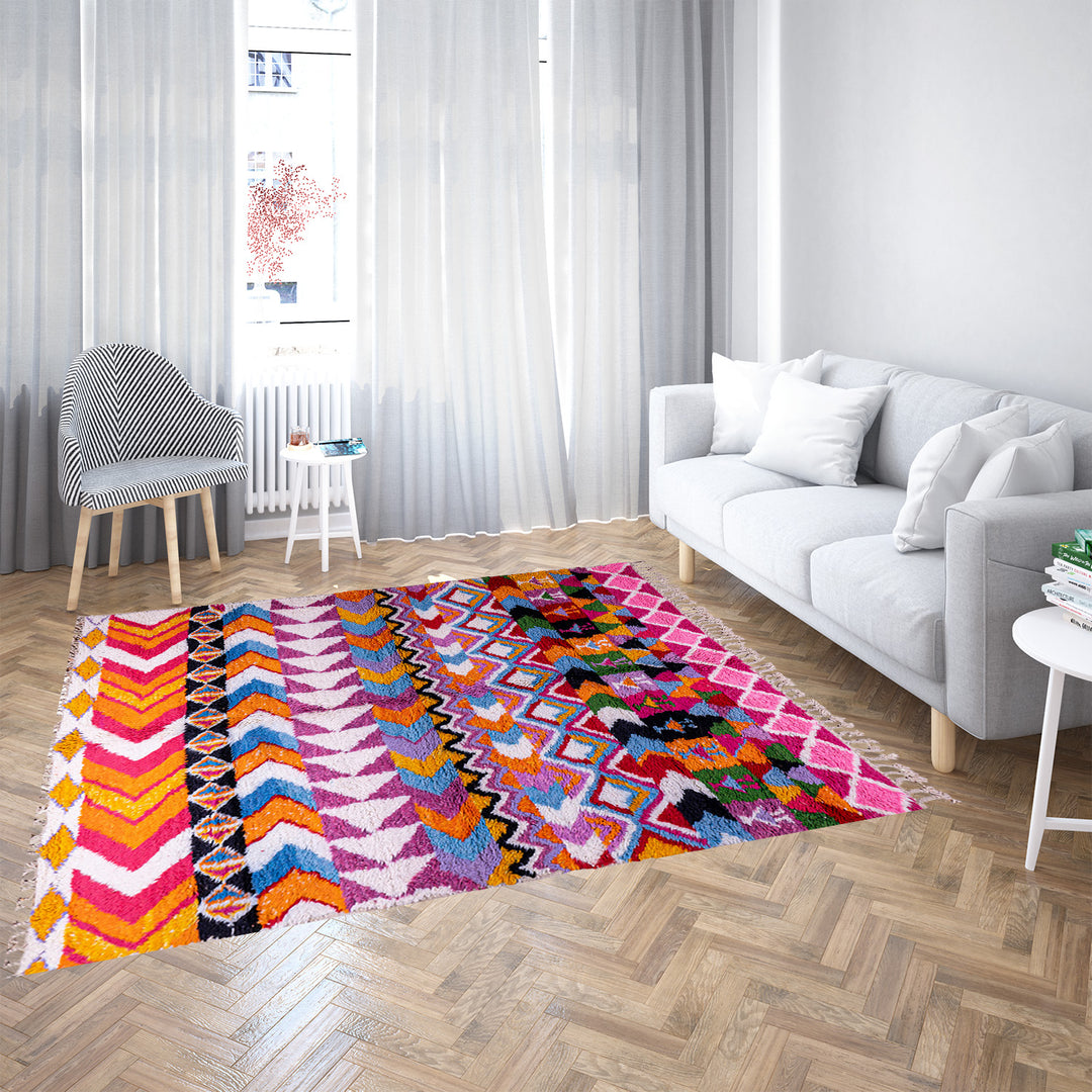 Large colorful Moroccan rug with bold geometric Berber patterns in pink, orange, blue, and yellow