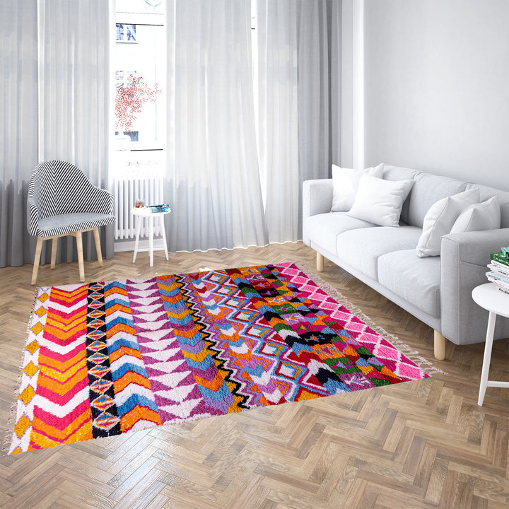 Large colorful Moroccan rug with bold geometric Berber patterns in pink, orange, blue, and yellow