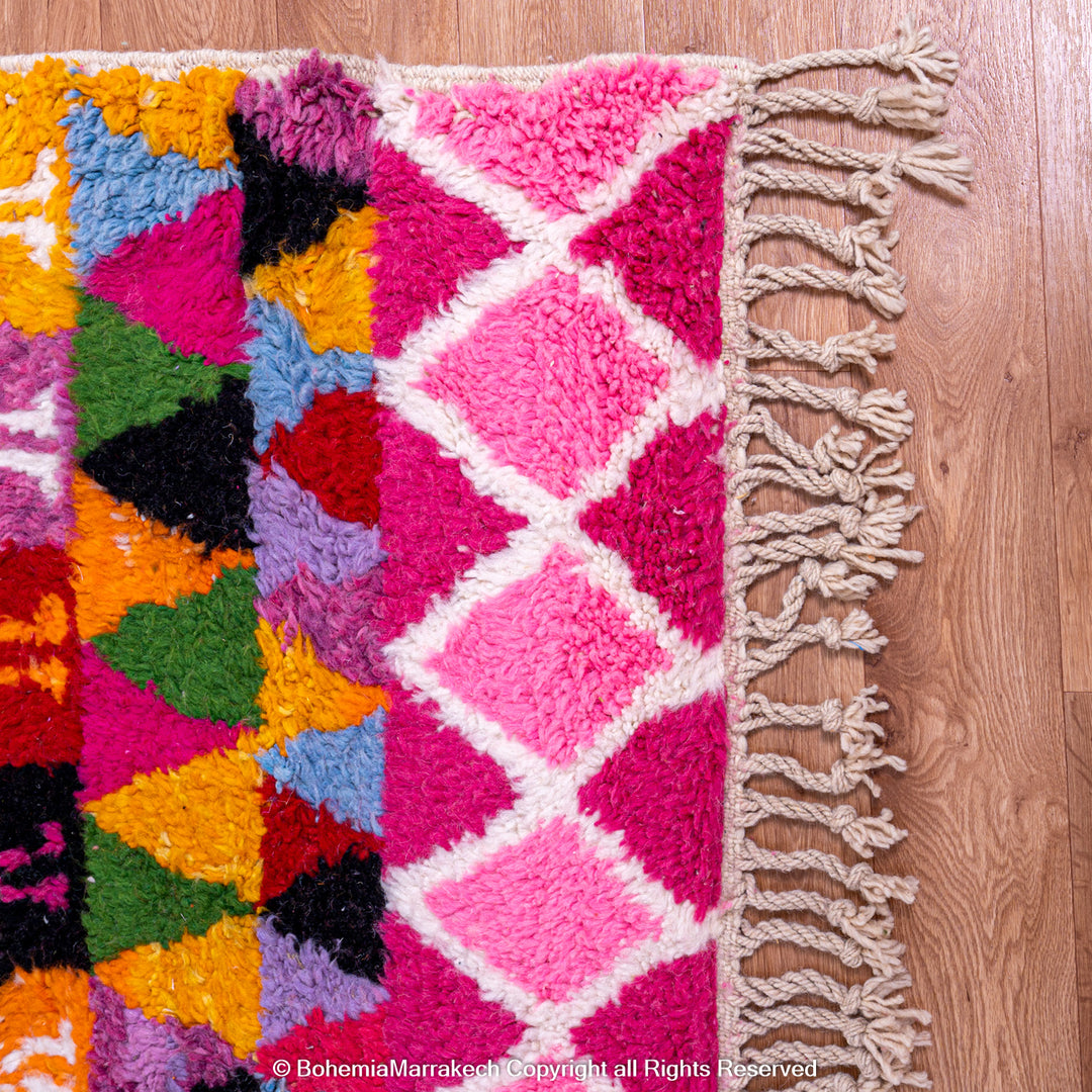 Large colorful Moroccan rug with bold geometric Berber patterns in pink, orange, blue, and yellow
