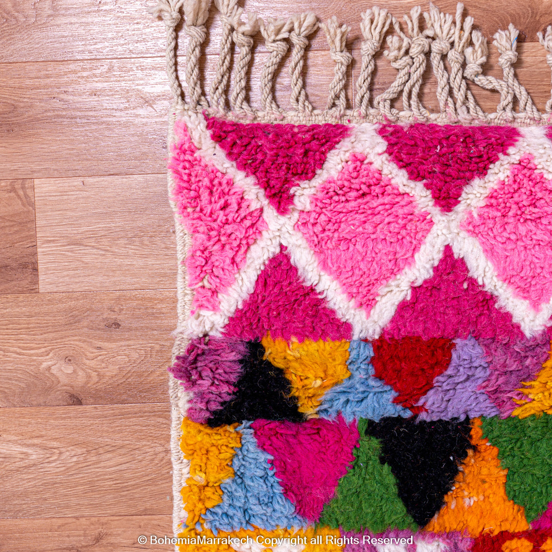 Large colorful Moroccan rug with bold geometric Berber patterns in pink, orange, blue, and yellow