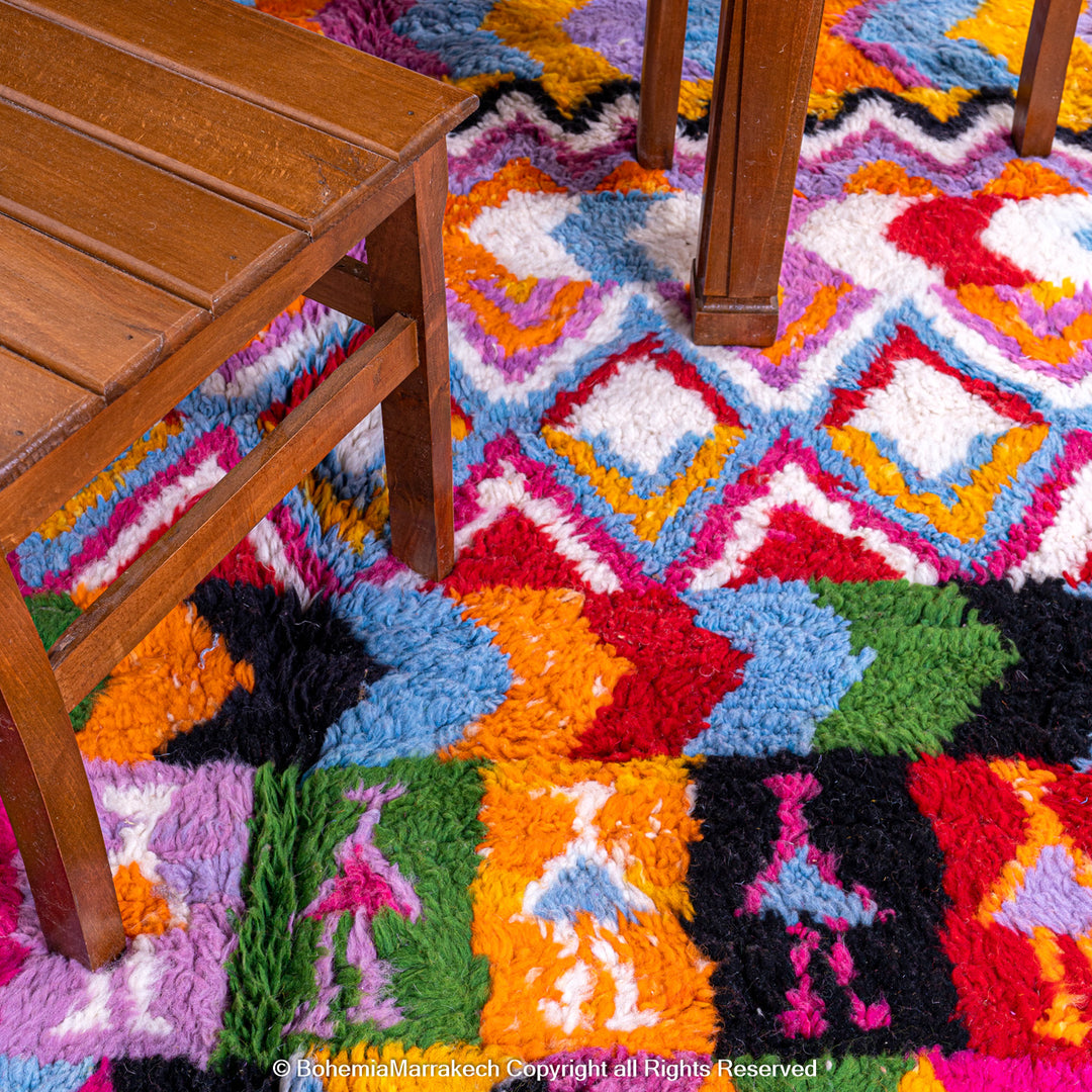 Large colorful Moroccan rug with bold geometric Berber patterns in pink, orange, blue, and yellow