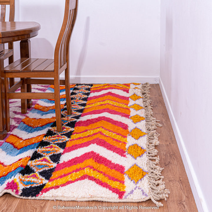 Large colorful Moroccan rug with bold geometric Berber patterns in pink, orange, blue, and yellow