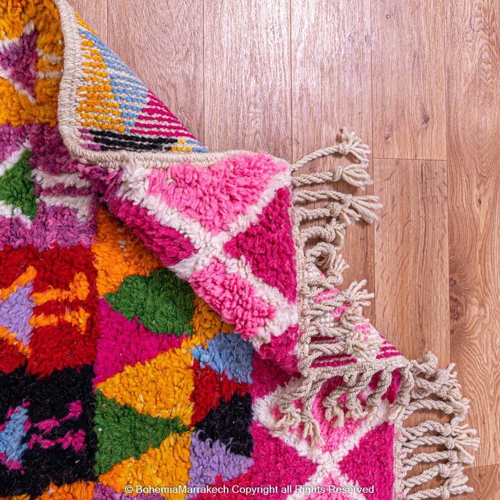 Large colorful Moroccan rug with bold geometric Berber patterns in pink, orange, blue, and yellow