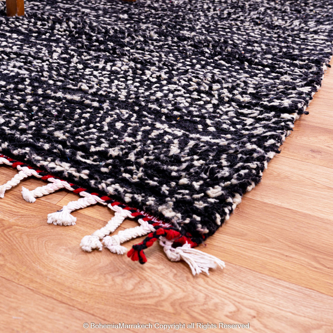 Handmade Moroccan runner rug featuring a traditional Berber symbol in red and black wool