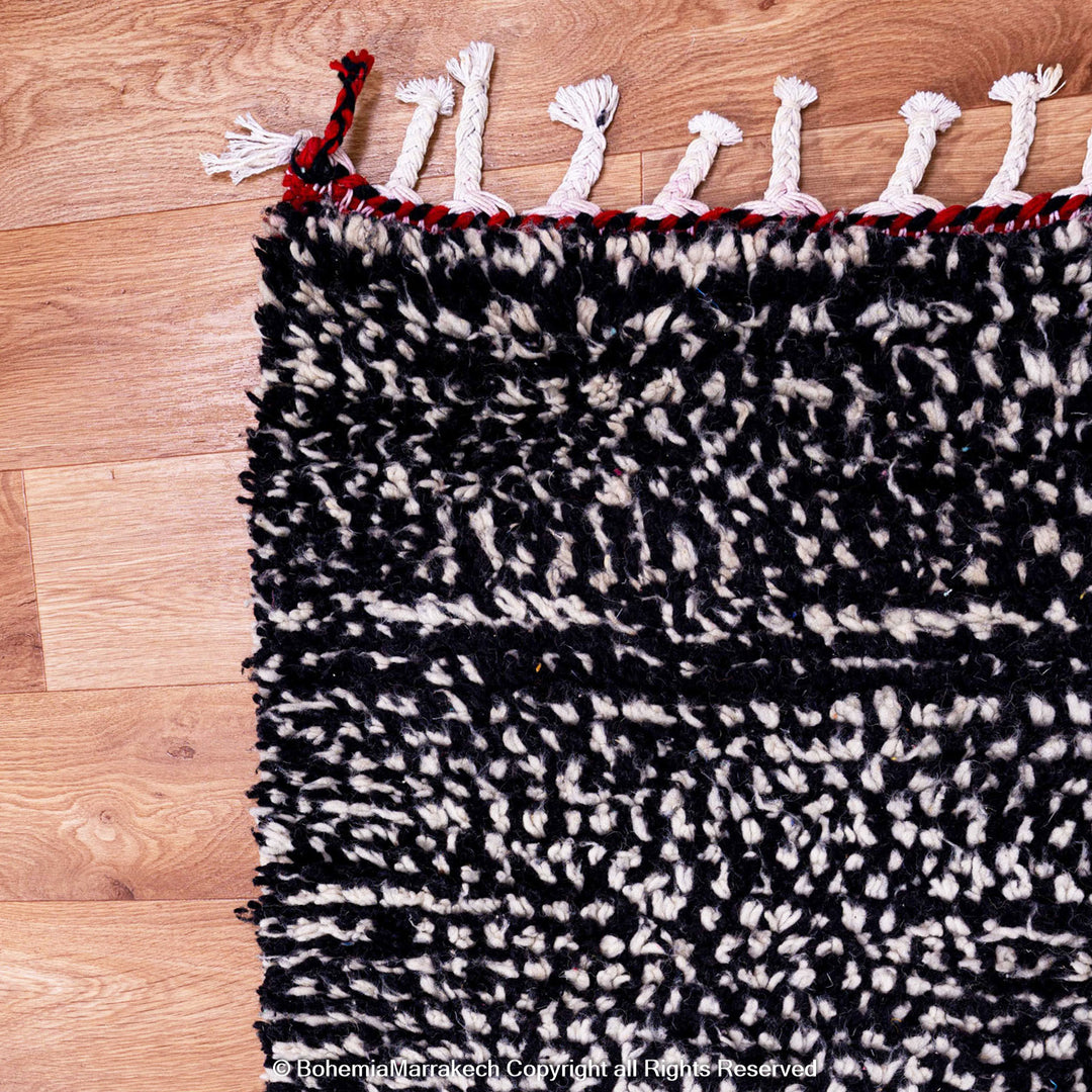 Handmade Moroccan runner rug featuring a traditional Berber symbol in red and black wool