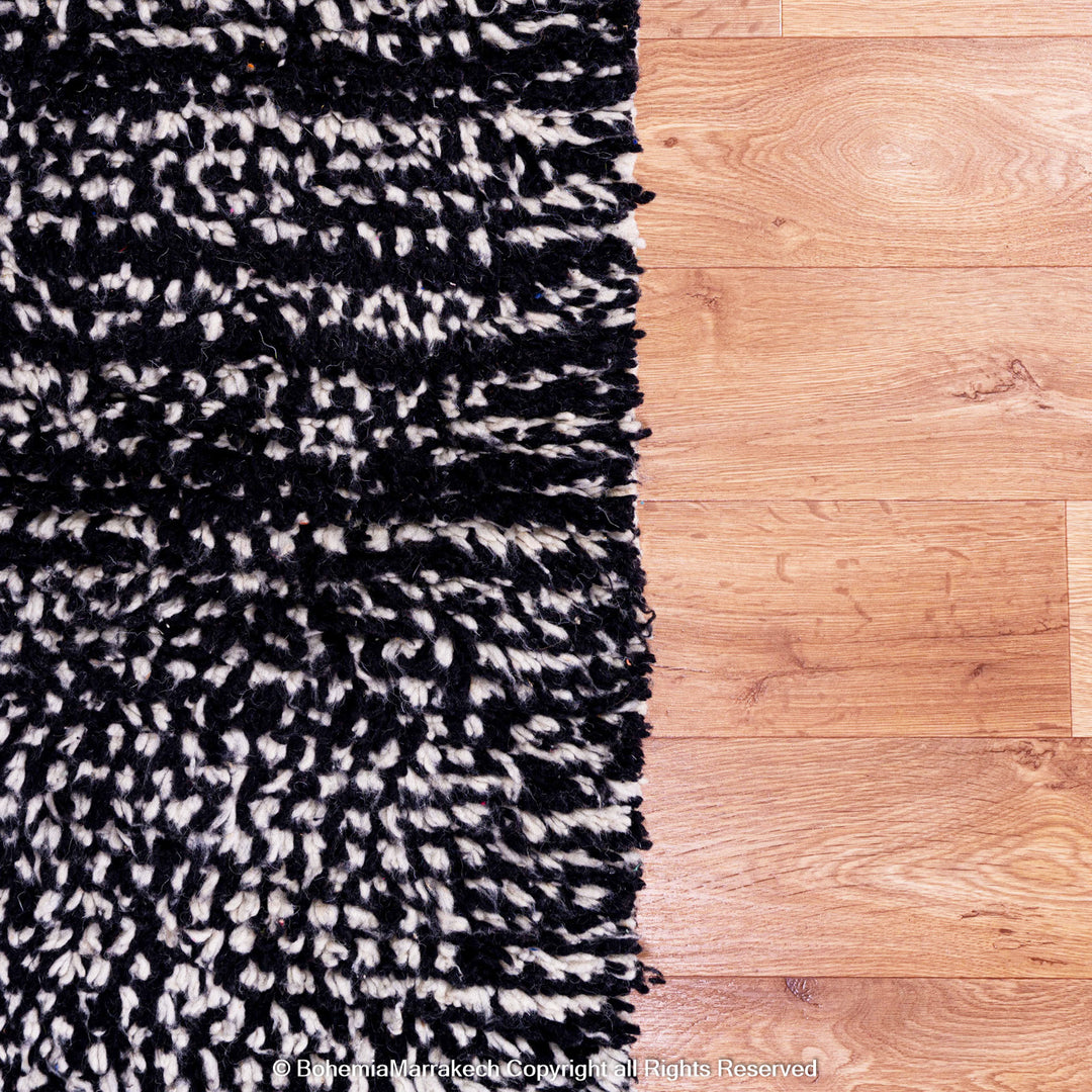 Handmade Moroccan runner rug featuring a traditional Berber symbol in red and black wool
