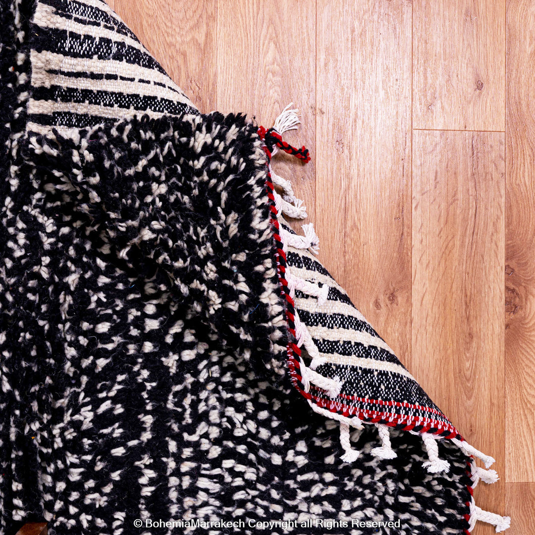 Handmade Moroccan runner rug featuring a traditional Berber symbol in red and black wool