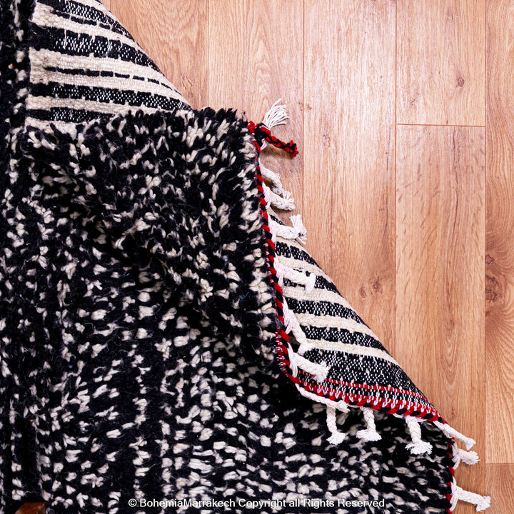 Handmade Moroccan runner rug featuring a traditional Berber symbol in red and black wool