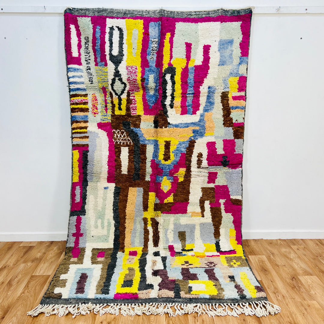 Colorful handmade Moroccan wool rug with abstract geometric patterns and vibrant hues, crafted by Berber artisans. Size: 278x151 cm.