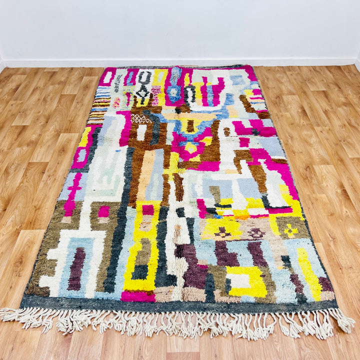 Colorful Moroccan wool rug with abstract geometric pattern, vibrant magenta, mustard, blue hues, handmade by Berber artisans