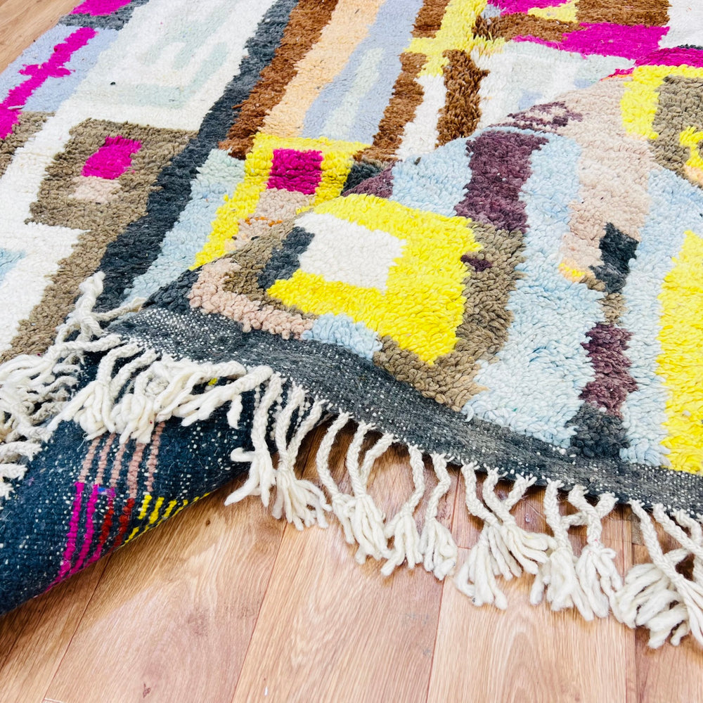 Colorful Moroccan wool rug with abstract geometric patterns on hardwood floor