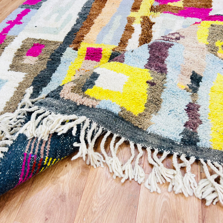 Colorful Moroccan wool rug with abstract geometric patterns on hardwood floor
