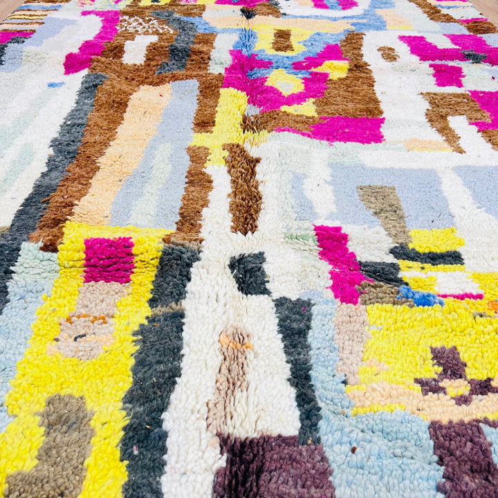 Colorful Moroccan wool rug with abstract geometric design in magenta, yellow, blue, soft grey, handmade by Berber artisans.