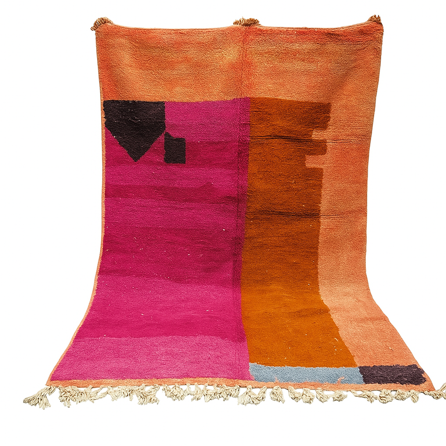 Handwoven Moroccan wool rug in magenta pink and burnt orange color blocks with black and blue accents, fringed ends