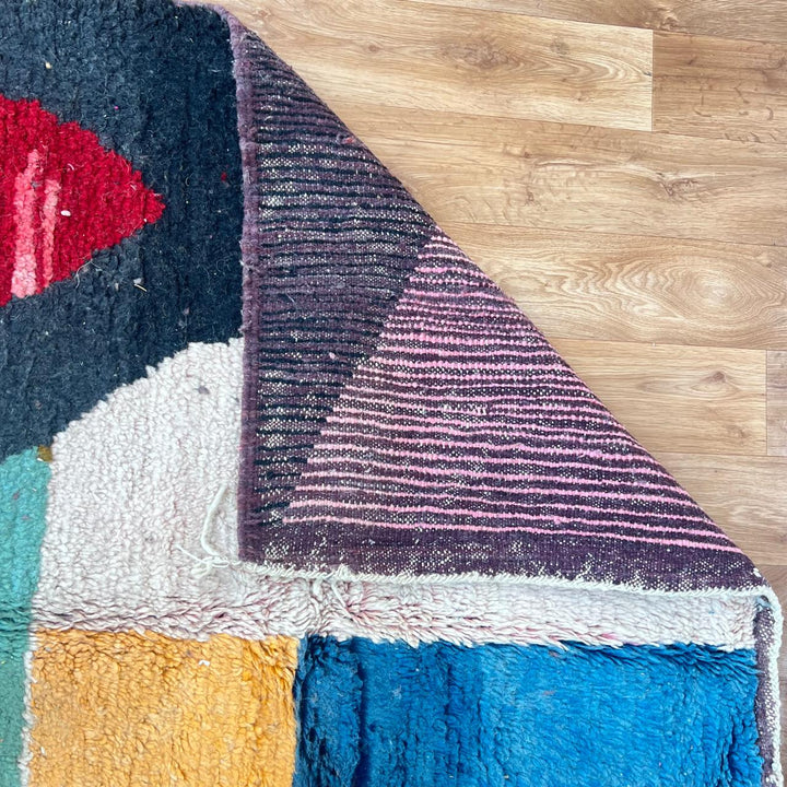 Vintage Moroccan Wool Rug BM168 – handmade geometric color block Moroccan rug in red, blue, and mustard tones (250 × 143 cm).