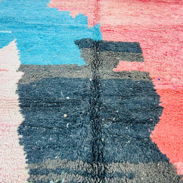 Vintage Moroccan wool rug with abstract coral pink, blue, and black color-block geometric design, handwoven Berber carpet from Morocco.