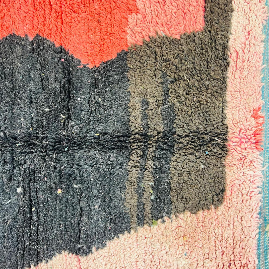 Vintage Moroccan wool rug with abstract coral pink, blue, and black color-block geometric design, handwoven Berber carpet from Morocco.