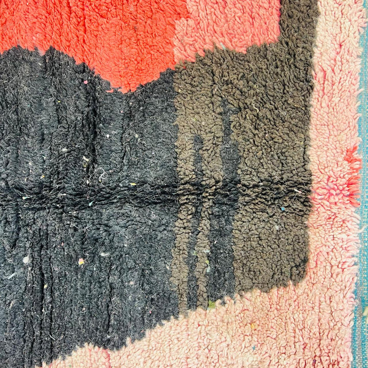 Vintage Moroccan wool rug with abstract coral pink, blue, and black color-block geometric design, handwoven Berber carpet from Morocco.