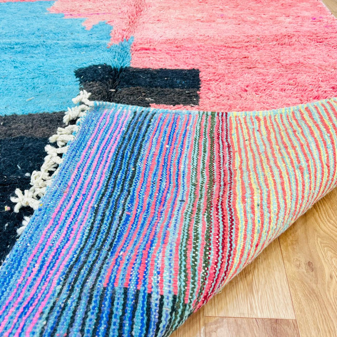 Vintage Moroccan wool rug with abstract coral pink, blue, and black color-block geometric design, handwoven Berber carpet from Morocco.