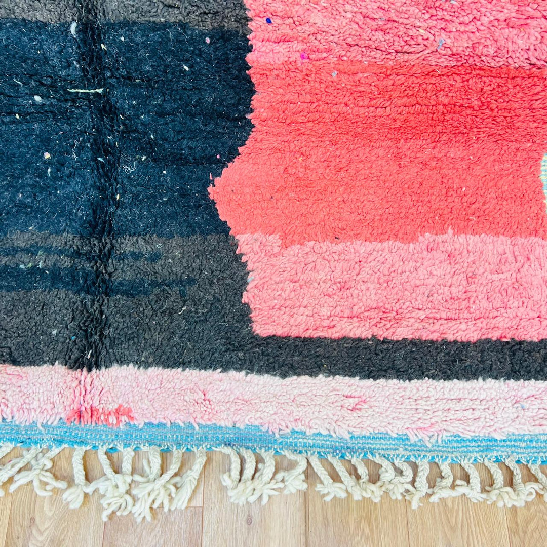 Vintage Moroccan wool rug with abstract coral pink, blue, and black color-block geometric design, handwoven Berber carpet from Morocco.
