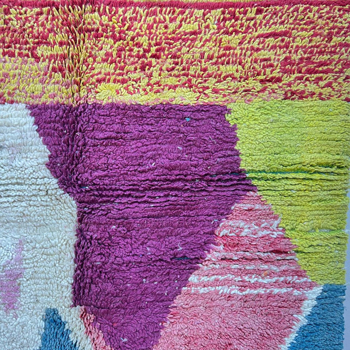 Vintage Moroccan wool rug BM31 – handmade blue, pink, and yellow abstract geometric design (253 × 148 cm).