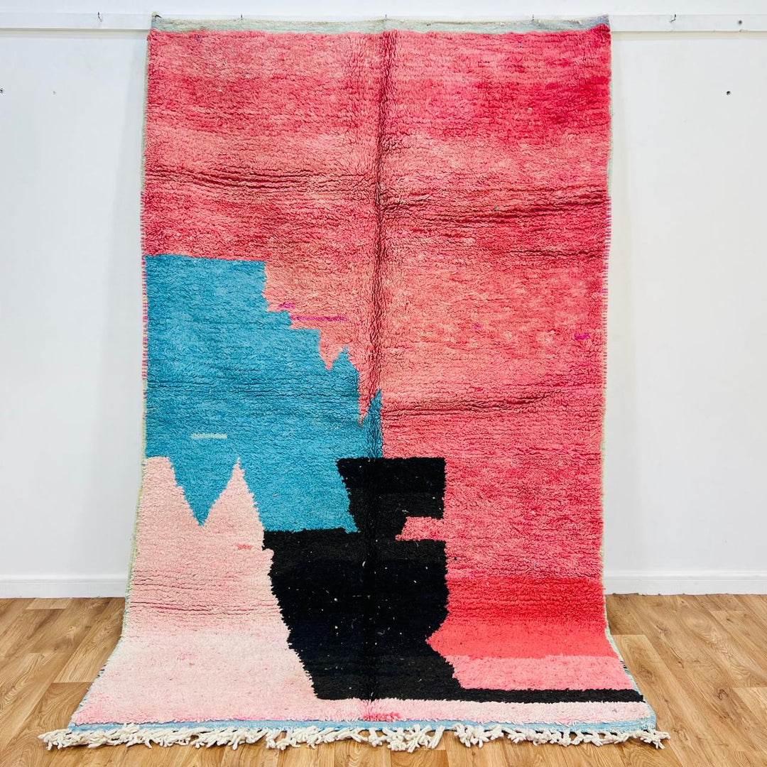 Vintage Moroccan wool rug with abstract coral pink, blue, and black color-block geometric design, handwoven Berber carpet from Morocco.