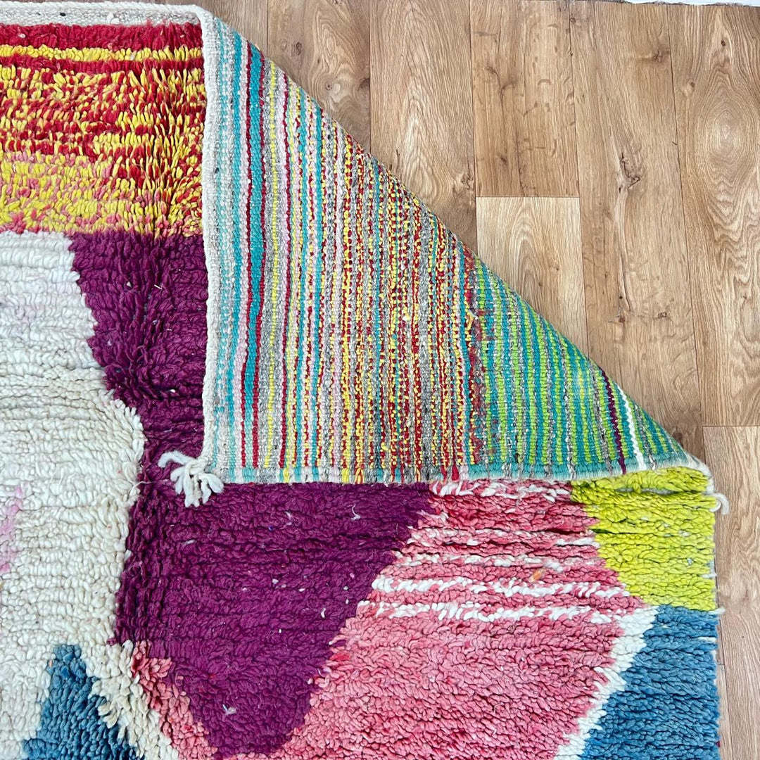 Vintage Moroccan wool rug BM31 – handmade blue, pink, and yellow abstract geometric design (253 × 148 cm).