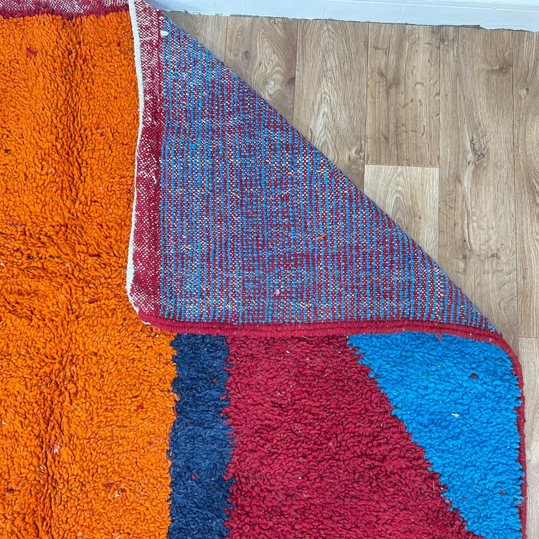 Vintage Moroccan wool rug 201 – handmade red, blue, and orange abstract geometric design (243 × 159 cm).