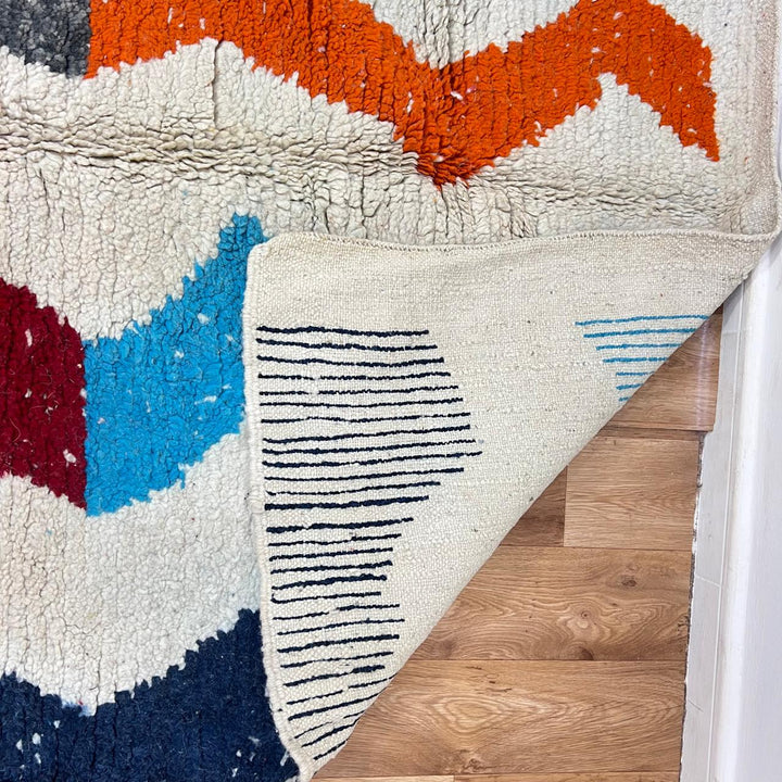 Vintage Moroccan wool rug 136 – handmade wavy pattern in blue, orange, red, and gray tones (221 × 150 cm).
