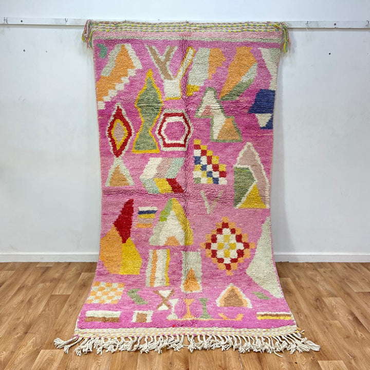 Vintage Moroccan wool rug 743 – handmade Berber carpet in pink with colorful geometric motifs in red, yellow, green, and blue, 268 × 144 cm (8.79 × 4.72 ft).
